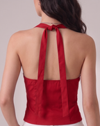 Red halter top with a bow detail worn by a person on a plain background